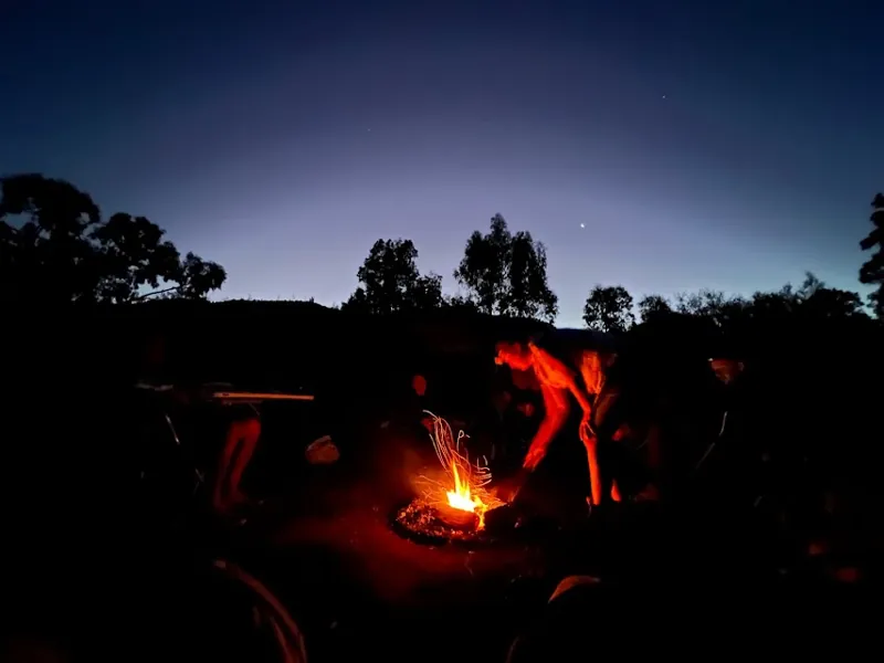 Campers gathered around a campfire at dusk