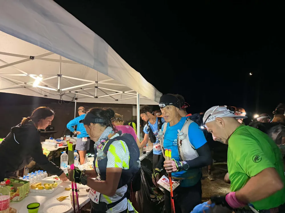 Trail-race volunteers working at a night-time aid station