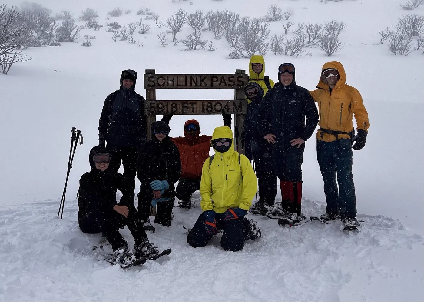 A Hikezilla group in snow gear at the Schlink Pass sign in Kosciuszko