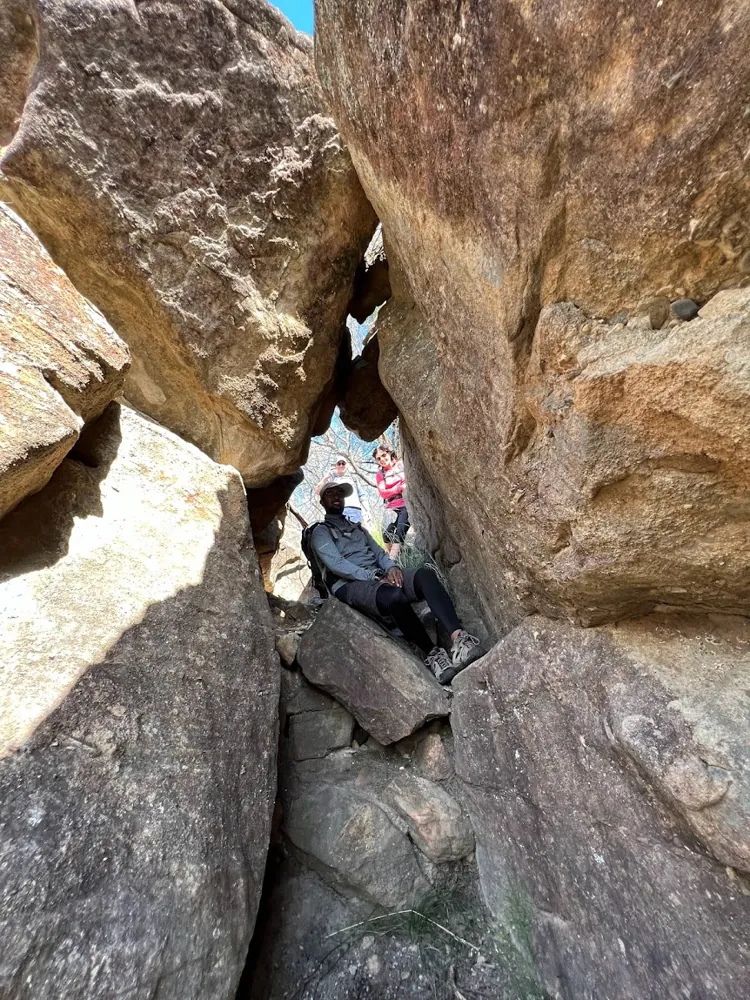 A hiker making their way through a narrow rock passage