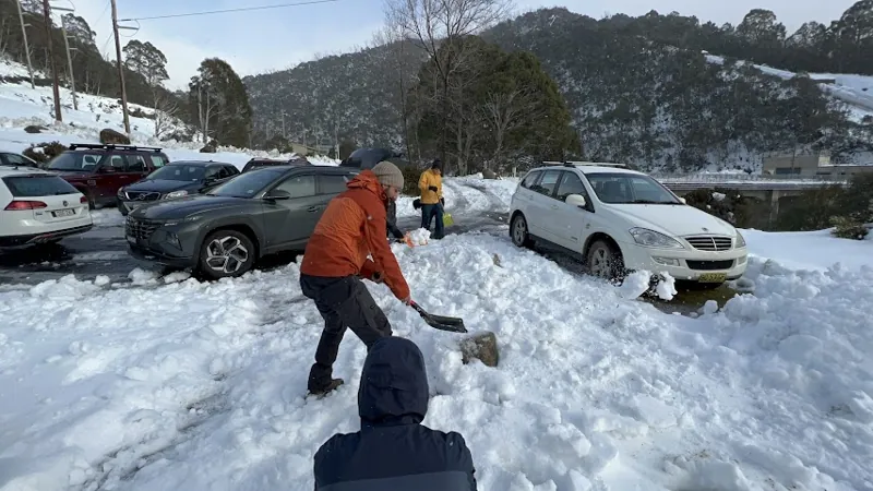 Carrying equipment through snow near parked cars